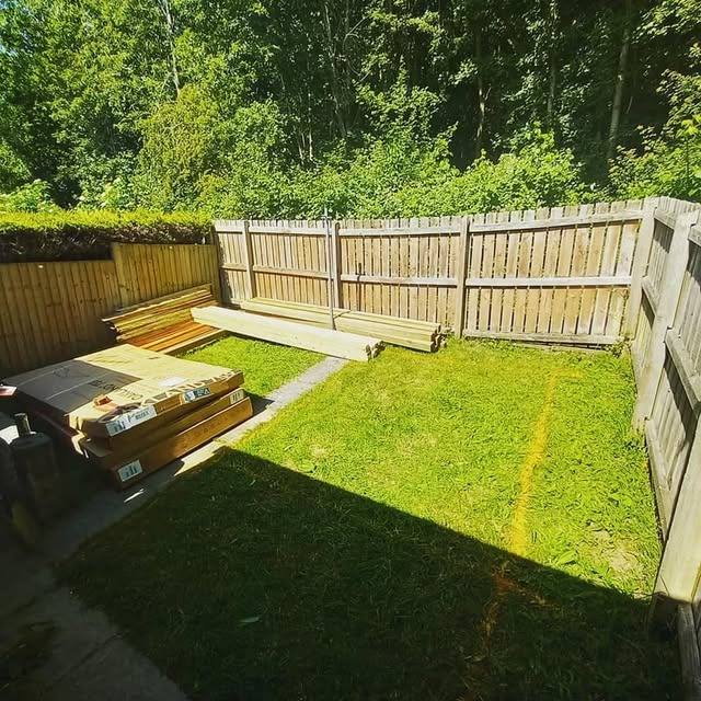 Decking timber and materials laid out on a garden lawn ready for building