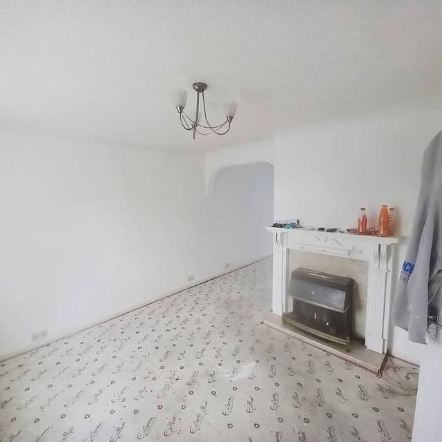 Living room renovation featuring new flooring and fireplace surround