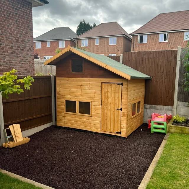 A bespoke timber shed under construction in a garden